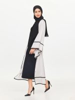 Left side view of the BEYOURA Elysian Draped Hush Robe in coconut milk styled with headscarf showing elegant drape